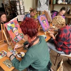 Deelnemers aan het werk tijdens de schilderworkshop Frida Kahlo (zelfportret) in het Abbehuisje in Abbekerk