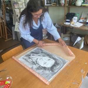 Een houtskool portret op handgeschept papier door Carolien van Oijen klaar om ingepakt en cadeau gegeven te worden.